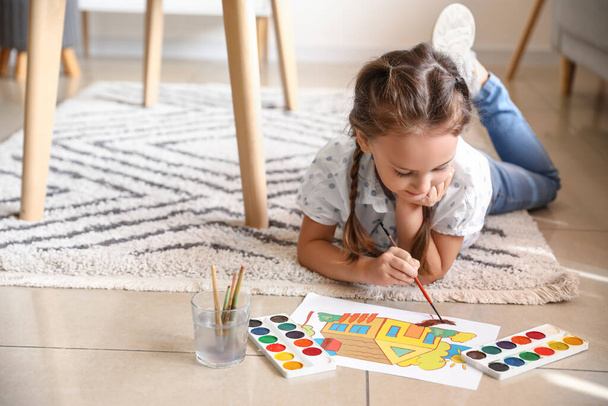 Little girl painting with watercolor paints on floor at home - Photo, Image