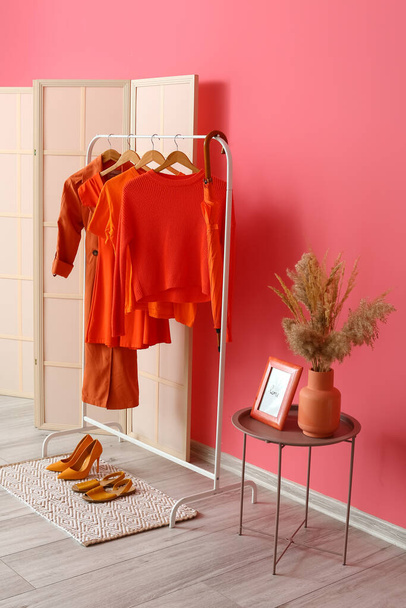 Interiér stylové chodby s jasně červeným oblečením a růžovou stěnou - Fotografie, Obrázek