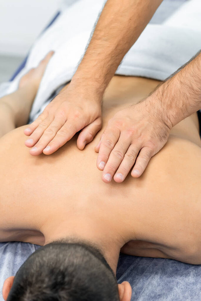 osteopath gives back massage to man - Foto, Imagen