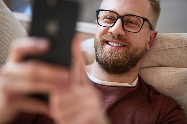 Content man taking selfie on smartphone at home - Valokuva, kuva