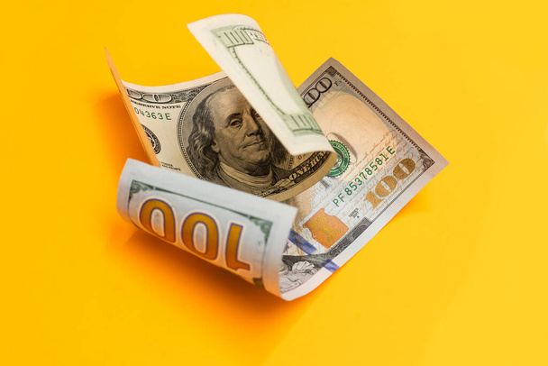Singolo Cento Dollaro Bill arricciato sul giallo - Foto, immagini