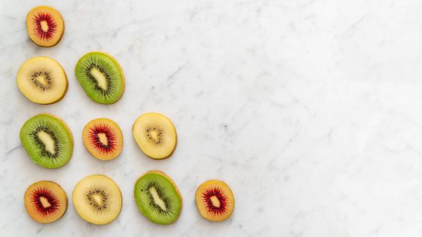 Pattern of Kiwi Fruit Slice Varieties from Above with Copy Space on Marble  - Photo, Image