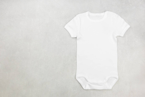 White baby girl or boy bodysuit mockup flat lay on the gray concrete background. Design onesie template, print presentation mock up. Top view.  - Fotoğraf, Görsel