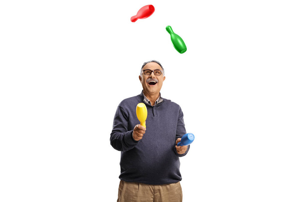Happy mature man juggling and smiling isolated on white background - Fotoğraf, Görsel