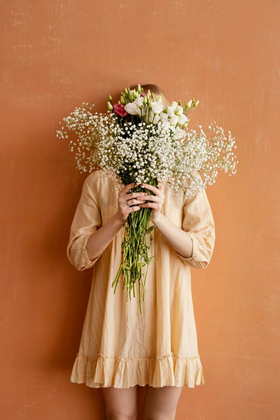 жінка з видом спереду тримає букет чудовими весняними квітами. Високоякісна фотографія
 - Фото, зображення