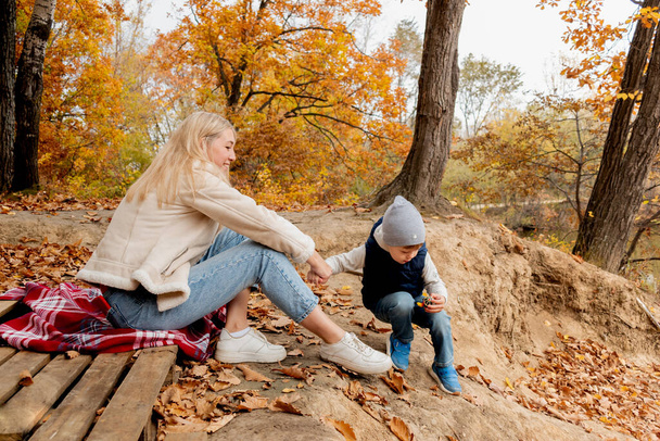 Mutter und Sohn spielen draußen im Wald. Konzept Familie Zeitvertreib. Herbststimmung. - Foto, Bild