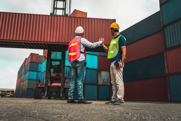 Промисловий робітник працює зі співробітником на судноплавному контейнерному подвір'ї
 - Фото, зображення