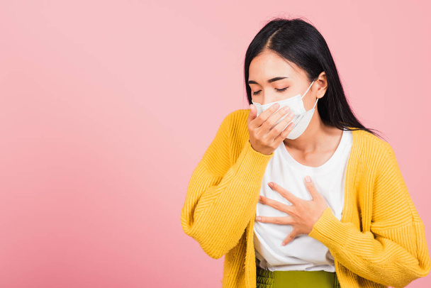 Asian beautiful young woman wearing medical mask protection for prevent infection coronavirus, COVID-19 she cough sneeze, studio shot isolated on pink background, Medical health care concept - Fotó, kép