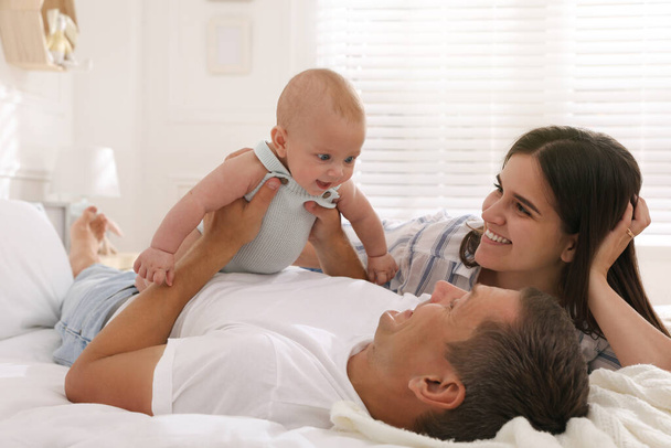 Happy family with their cute baby on bed at home - Zdjęcie, obraz