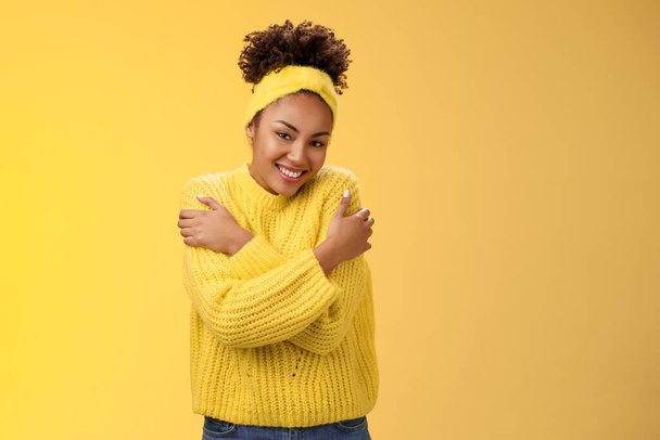 Atrakcyjny delikatny afrykańsko-amerykańska nastolatka dziewczyna w sweter opaska przytula się ręce dotykać ramiona czuć ciepły bezpieczny przytulny uśmiech szczęśliwie obejmujący przytulanie piękny chichot - Zdjęcie, obraz