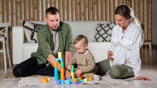 Parents et petit fils jouent avec des blocs de bois colorés - Photo, image