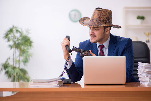 Fiatal cowboy üzletember dolgozik a munkahelyen - Fotó, kép
