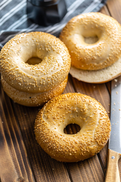 Baked bagel with sesame seeds on wooden table. - Foto, immagini