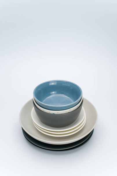 set of multicolored ceramic bowl and dishes on a white tabletop with copy space - Fotó, kép