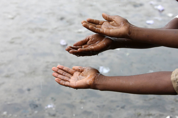 Regenzeit. Kinder, die mit Wasser spielen. Kongo-Brazzaville.  - Foto, Bild