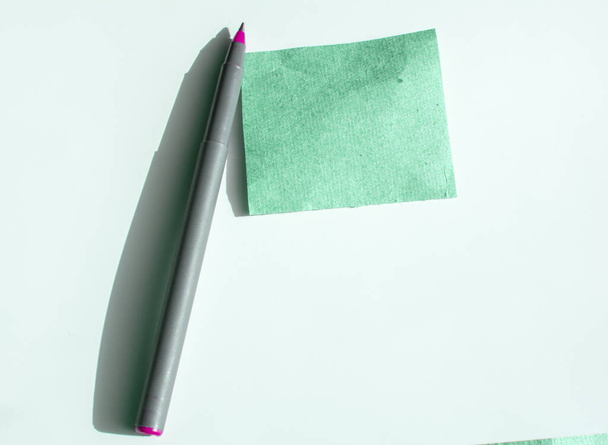Una tarjeta de papel verde vacía con un bolígrafo, una plantilla vacía y una maqueta para texto. - Foto, Imagen