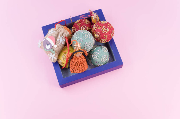 Multicolored Christmas decorative balls and figurines in a blue wooden box with sapce for text - Foto, afbeelding
