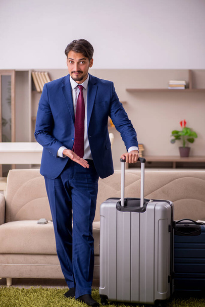 Jonge zakenman bereidt zich voor op reis naar huis - Foto, afbeelding