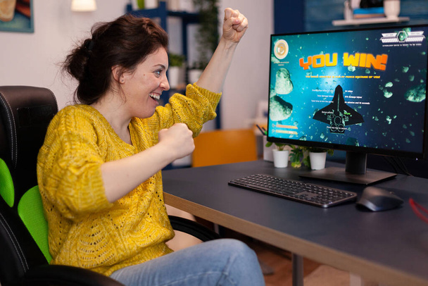 Aufgeregt glücklich wettbewerbsfähige Spielerfrau gewinnt Weltraum-Shooter-Videospiele - Foto, Bild
