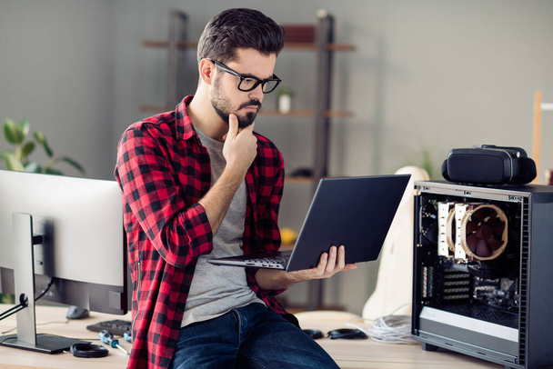 Portrait of attractive minded guy checking server error solving web network problem indoor at work place station - Foto, Imagem
