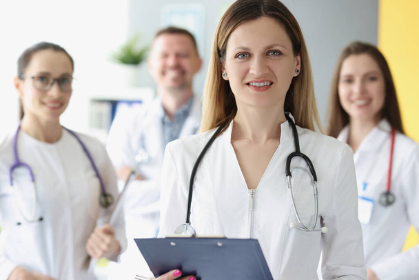Portrait of successful female doctor on background of colleagues - Photo, Image