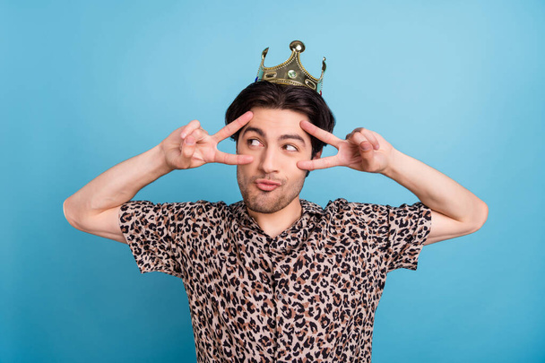 Portrait of attractive funky cheery guy wearing crown showing v-sign having fun party isolated over bright blue color background - Zdjęcie, obraz