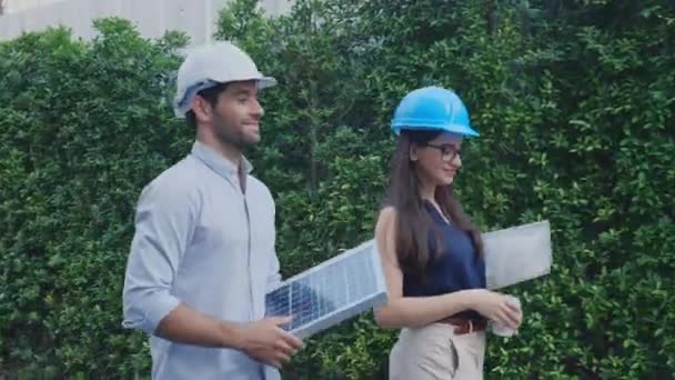 Engineer team walking and holding blueprint and solar cell panel greeting executive about deal, architect discussion and doing agreement together with partner with handshake for success. - Footage, Video