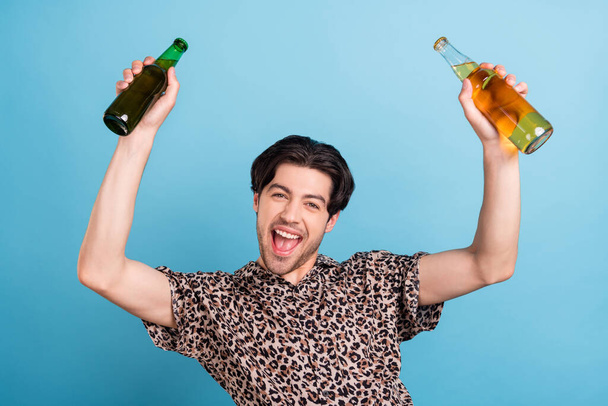 Portrait of attractive cheerful guy drinking beer celebrating great day weekend isolated over bright blue color background - Foto, Imagen