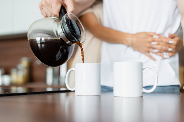 cropped view of man pouring coffee into cup  - Foto, Bild