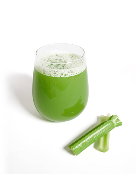 Vertical shot of a glass with celery smoothie isolated from the white background - Photo, Image