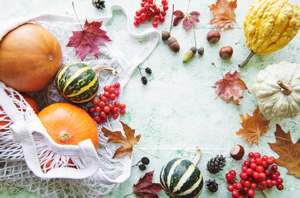 Herfst compositie met diverse pompoenen in eco string tas, thanksgiving achtergrond. - Foto, afbeelding