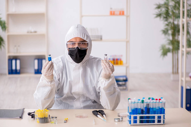 Jovem químico do sexo masculino que trabalha no laboratório durante a pandemia - Foto, Imagem