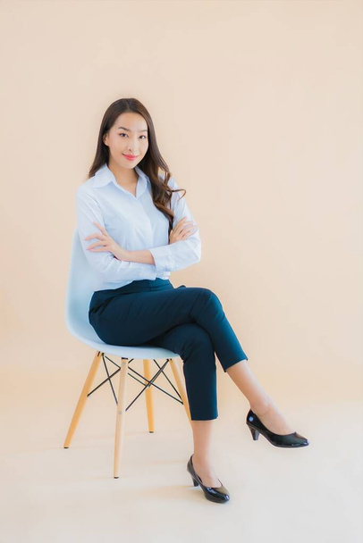 Portré gyönyörű fiatal üzleti ázsiai nő ül a széken laptop vagy okos telefon a munkához - Fotó, kép