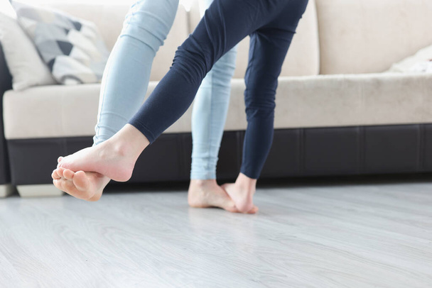 Bare feet mom and daughter dancing on floor of house closeup - Photo, Image