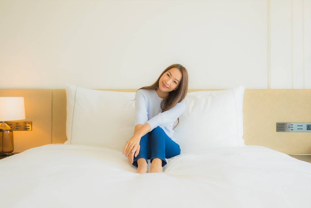 retrato hermosa joven asiática mujer relax sonrisa ocio en cama en dormitorio interior - Foto, imagen