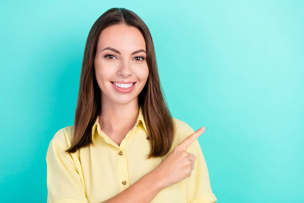 Photo of lovely millennial brunette lady index empty space wear yellow top isolated on teal color background - Φωτογραφία, εικόνα
