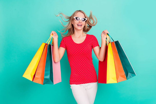Photo of young woman happy positive smile hold shopping bags black friday isolated over turquoise color background - Fotoğraf, Görsel