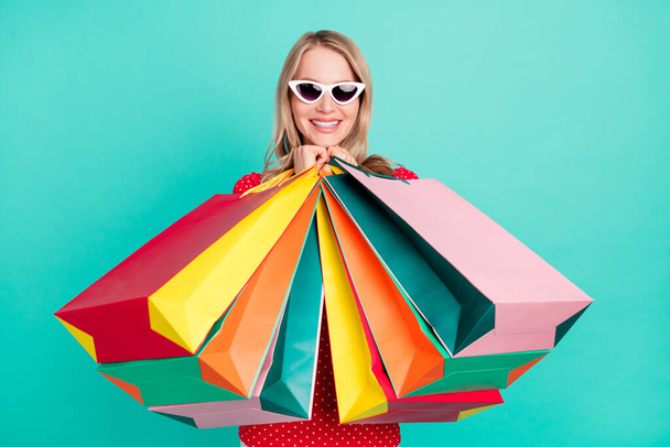 Фотопортрет жінки, що тримає сумки, покупки в стильному сонцезахисному окулярі ізольовані яскравий кольоровий фон
 - Фото, зображення
