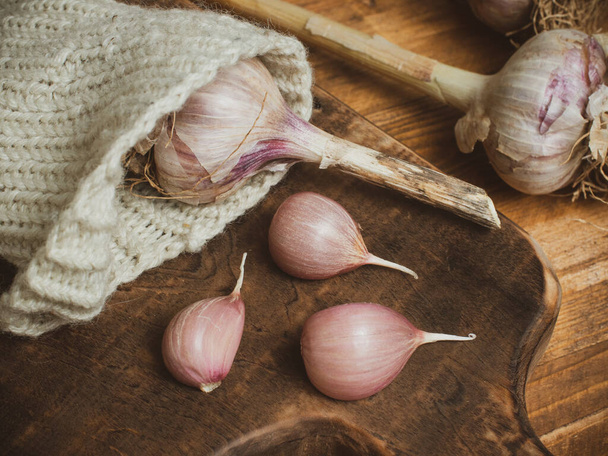 dry garlic on a wooden cutting board. fresh garlic as a means for weight loss. healthy food. - Fotoğraf, Görsel