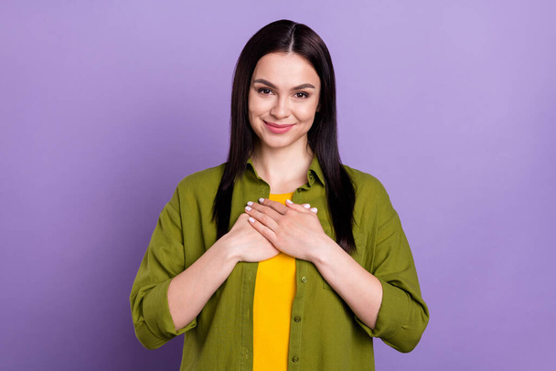 Photo of shiny impressed young lady dressed green clothes smiling arms chest isolated purple color background - Foto, Imagem