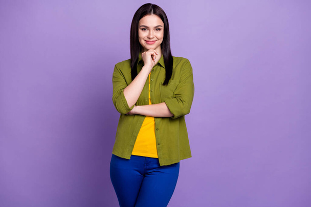 Photo of charming thoughtful young lady dressed green clothes arm chin smiling isolated purple color background - 写真・画像