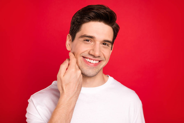 Photo portrait brunet wearing casual t-shirt smiling touching skin after barbershop isolated bright red color background - Photo, Image