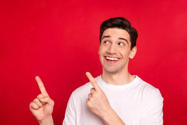 Photo portrait brunet guy in white shirt laughing pointing fingers empty space dreamy isolated vivid red color background - Foto, afbeelding