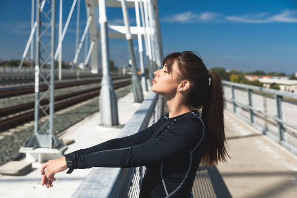 Young happy self loved sporty fitness runner woman standing and taking a break after hard running and jogging exercise for healthy life and clear mind preparing for marathon, female in sport concept - 写真・画像