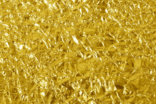 Blattgold glänzende Textur, abstraktes gelbes Packpapier für Hintergrund und Design. - Foto, Bild