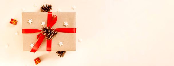 Χριστουγεννιάτικο κουτί δώρου με κόκκινο φιόγκο σε μπεζ φόντο. Holiday concept, Πρωτοχρονιά παρουσιάζει. - Φωτογραφία, εικόνα
