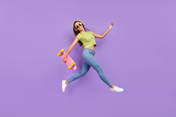 Full length body size view of nice trendy cheerful girl jumping listening song having fun going isolated over purple violet color background - Foto, Bild