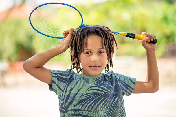 Closeup cute little black American boy holding a badminton racket, Outdoor - Fotó, kép