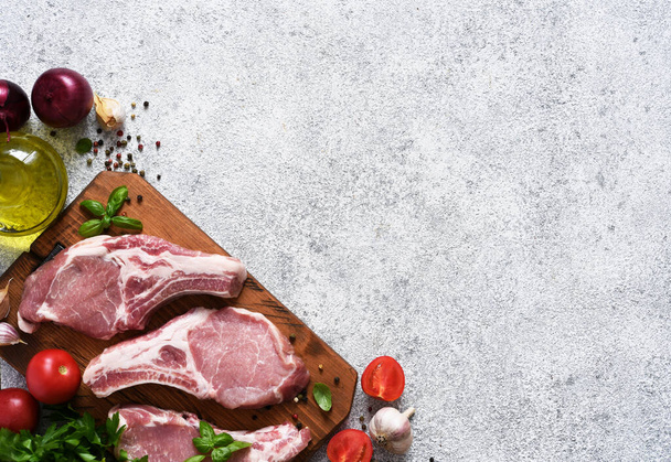 Pork steak and spices, vegetables, oil on a light background. Fresh meat. Advertising. Food delivery. - Foto, imagen