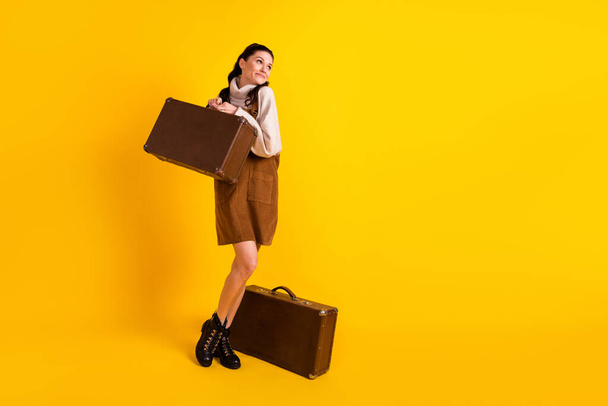 Full length body size view of attractive cheerful dreamy girl carrying bag tourism isolated over bright yellow color background - Foto, imagen